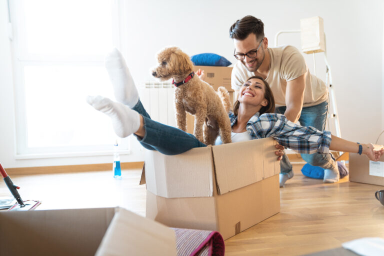 Young playful couple moving into new house.